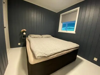 a small bedroom with a bed with a window at Askevika in Vikum