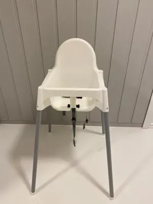 a white high chair sitting in a room at Askevika in Vikum