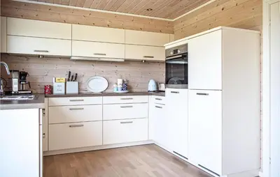 a kitchen with white cabinets and a wooden ceiling at 3 Bedroom Awesome Home In Skjold in Skjold