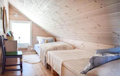 two beds in a room with wooden walls at 3 Bedroom Awesome Home In Skjold in Skjold