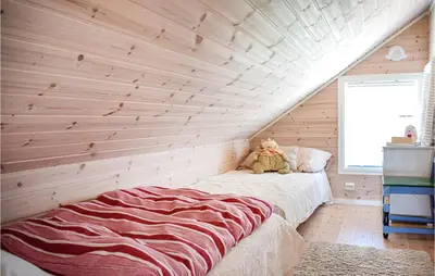 a bedroom with wooden walls and a bed with a teddy bear at 3 Bedroom Awesome Home In Skjold in Skjold