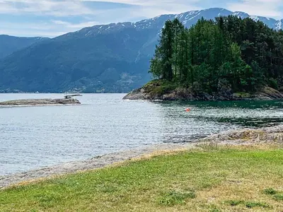 a large body of water with mountains in the background at Seaside Serenity in Hardangerfjord-By Traum in Tyrvikbygd