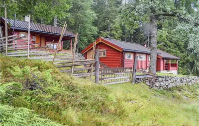 a red cabin in the middle of a forest at Høgesset in Feiring
