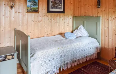 a bedroom with a bed in a wooden wall at Høgesset in Feiring