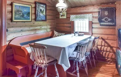 a dining room with a table and chairs in a cabin at Høgesset in Feiring