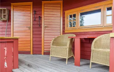 a patio with two chairs and a table on a house at Høgesset in Feiring