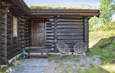 two chairs sitting outside of a log cabin at 3 Bedroom Amazing Home In Uvdal in Uvdal