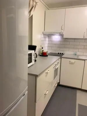 a kitchen with white cabinets and a microwave at Private house-terrace-garden -parking-WiFi-smartTV in Trondheim