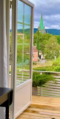 an open window with a view of a church at Private house-terrace-garden -parking-WiFi-smartTV in Trondheim