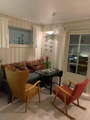 a living room with a couch and a table and chairs at Private house-terrace-garden -parking-WiFi-smartTV in Trondheim