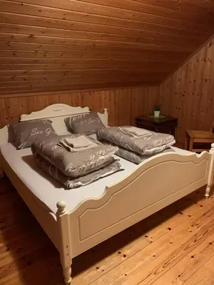 a bed with three pillows on top of it at Sjarmerende overnatting sentralt i Vest-Telemark in Høydalsmo