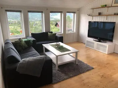 a living room with a couch and a table and a tv at Ramsbu utsikt terasse selvhushold in Hovden