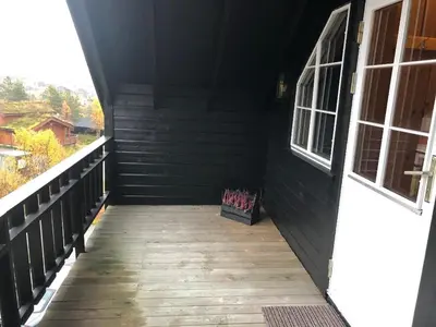 a porch of a house with a wooden floor and a window at Ramsbu utsikt terasse selvhushold in Hovden