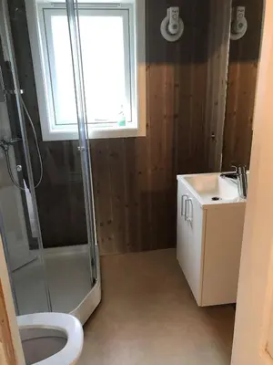 a bathroom with a shower and a toilet and a sink at Ramsbu utsikt terasse selvhushold in Hovden