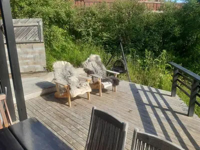 a deck with two chairs and a bench on it at Ramsbu utsikt terasse selvhushold in Hovden
