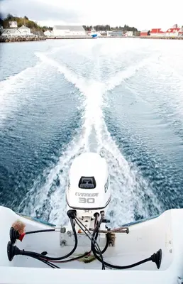 a boat in the water with the wake at Marthas Rorbu in Bakkasund