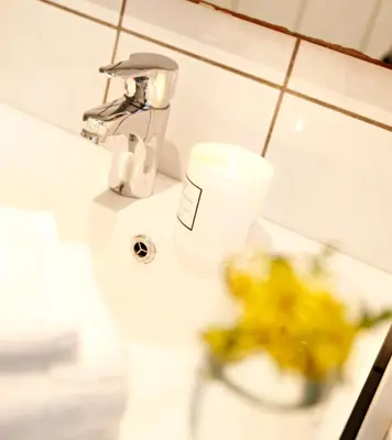 a bathroom sink with a cup on the counter at Marthas Rorbu in Bakkasund