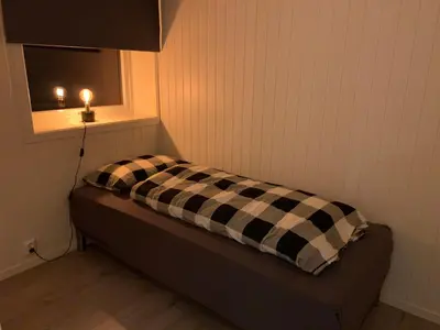 a bed in a room with a window and a pillow at Stryn Crystal Apartments - Waterfront Apartment in Stryn