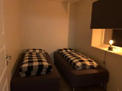 two beds in a small room with a window at Stryn Crystal Apartments - Waterfront Apartment in Stryn