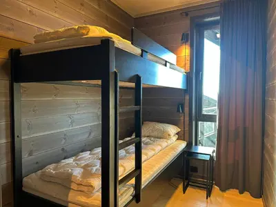 a bunk bed room with two bunk beds and a window at Ridderleiligheter in Beitostøl
