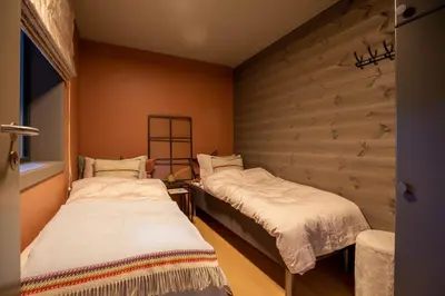 two beds in a room with a wall at Ridderleiligheter in Beitostøl