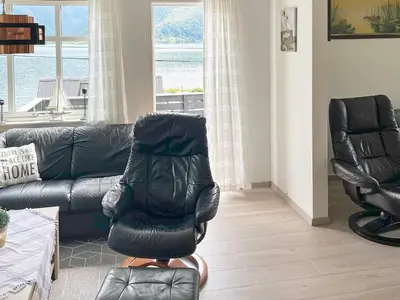 a living room with a leather chair and a couch at 8 person holiday home in Barmen in Barmen