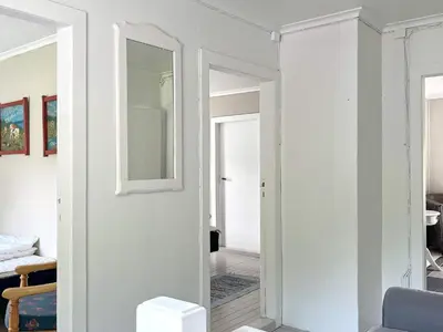 a white room with a mirror and a hallway at 8 person holiday home in Barmen in Barmen