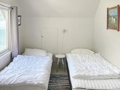a room with two beds and a table and a window at 8 person holiday home in Barmen in Barmen