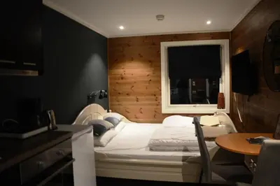 a room with a bed with a window and a table at Fossheim Lodge - arealeffektiv minileilighet in Torset