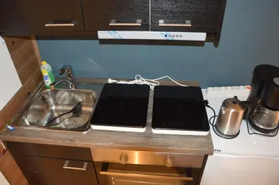 a kitchen counter with two laptops on top of it at Fossheim Lodge - arealeffektiv minileilighet in Torset