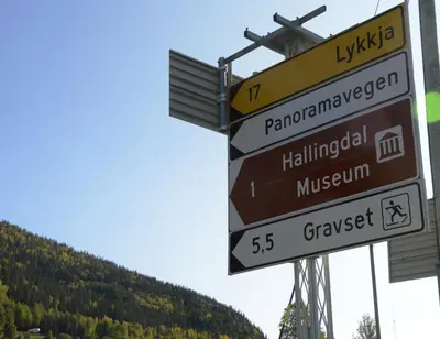 a bunch of street signs in front of a mountain at Fossheim Lodge - arealeffektiv minileilighet in Torset