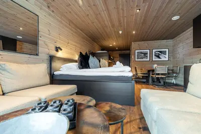 a room with a bed and a couch and a table at Skigaarden in Hemsedal