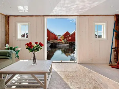 a living room with a table and a vase of flowers at 7 person holiday home in Bud in Bud