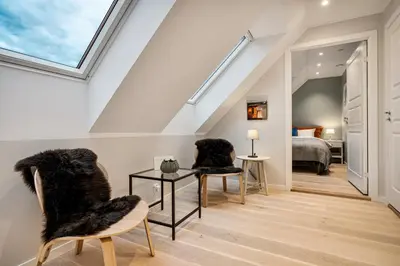 a room with two chairs and a bed and a skylight at Keyser Apartments 8 in Bergen