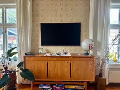 a living room with a television on top of a cabinet at Apotekbygget in Nesbyen
