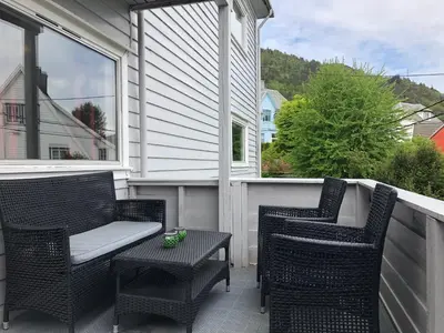 a porch with two chairs and a bench and a table at # 1 Mountain View with free street parking in Bergen