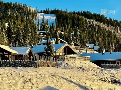 a ski lodge in the snow with trees at Modern sports cabin on Sjusjøen with sauna and waxing room in Ringsaker