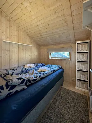 a bedroom with a bed in a wooden cabin at Modern sports cabin on Sjusjøen with sauna and waxing room in Ringsaker