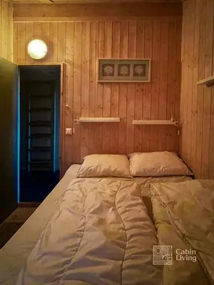 a large bed in a room with wooden walls at Modern sports cabin on Sjusjøen with sauna and waxing room in Ringsaker