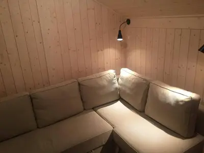 a white couch with white pillows in a room at Modern sports cabin on Sjusjøen with sauna and waxing room in Ringsaker