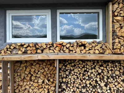 a pile of fire wood and two windows at Bjørkli Lodge in Geilo
