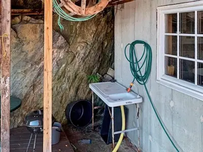 a house with a sink and a hose next to a window at 6 person holiday home in HOSTELAND in Hosteland