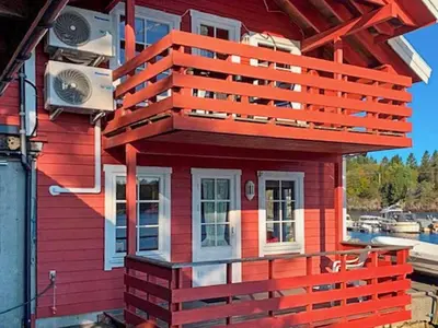 a red house with a balcony on top of it at 6 person holiday home in HOSTELAND in Hosteland
