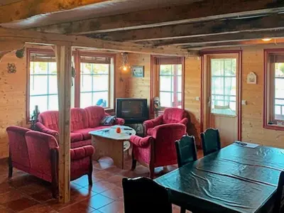 a living room with red chairs and a table at 6 person holiday home in HOSTELAND in Hosteland