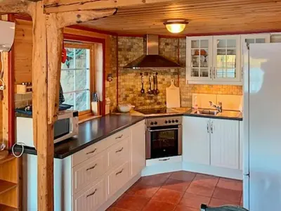 a kitchen with white cabinets and a stove top oven at 6 person holiday home in HOSTELAND in Hosteland