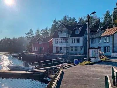 a group of houses next to a body of water at 6 person holiday home in HOSTELAND in Hosteland