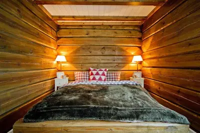 a bedroom with a bed in a log cabin at Large family cabin in Hafjell ski in-out, BBQ, terrace and fireplace in Hafjell