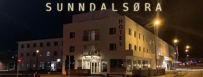 a building with a sign on top of it at night at Sunndalsøra Hotell in Sunndalsøra