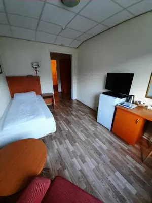 a room with a bed and a desk and a tv at Sunndalsøra Hotell in Sunndalsøra