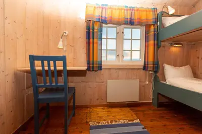 a blue chair in a room with a bunk bed at Nordpå Fjellhotell AS in Haltdalen